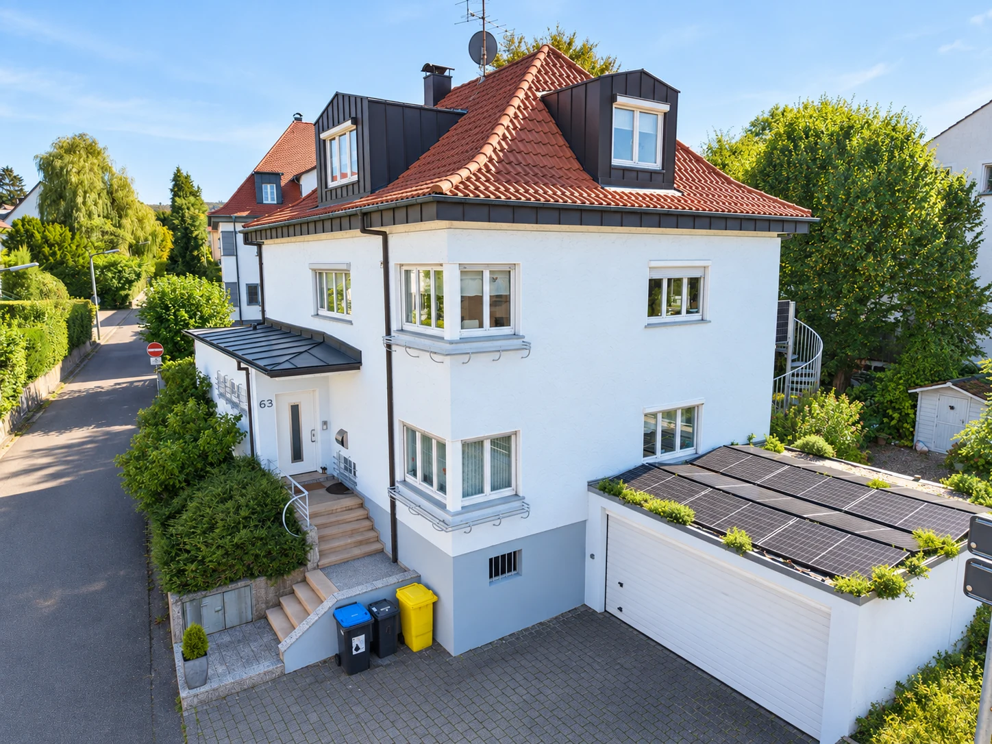 Stadtvilla in Schorndorf mit heller Fassade, Walmdach und Garage mit Solarmodulen